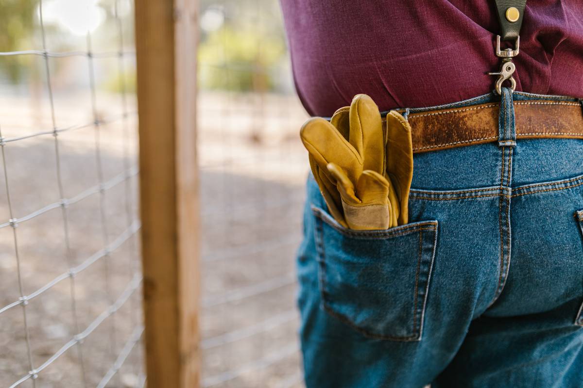 Duty belt support system worn by a carpenter on a residential job site, showing padded suspenders and balanced tool distribution